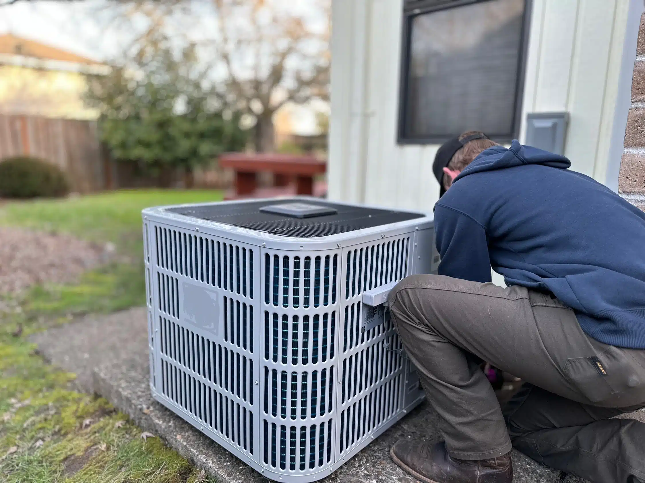 A Durfee technician servicing a heat pump at a Cape Cod home.