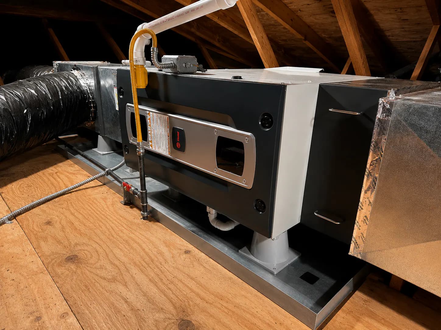 An attic air handler and ductwork installed by Durfee Plumbing & Heating in a Cape Cod home.