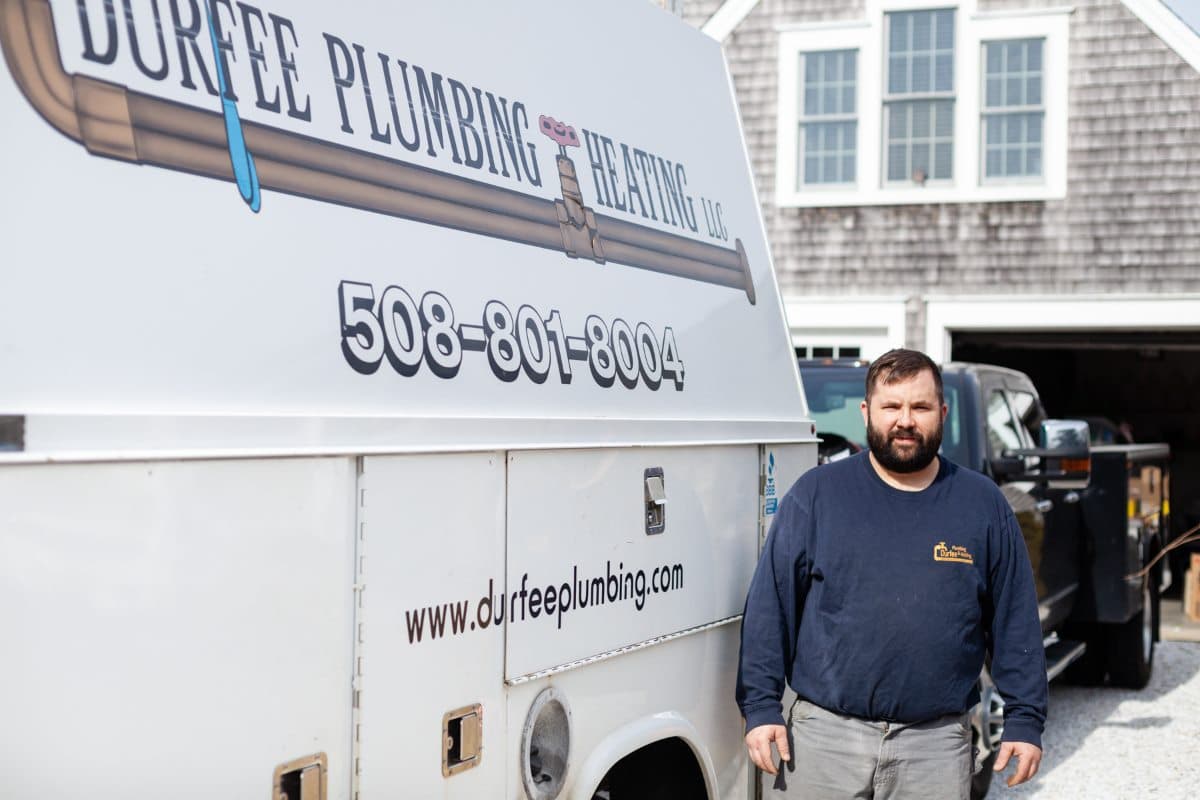 Phil Durfee standing beside a Durfee Plumbing and Heating service truck in South Dennis, Massachusetts.